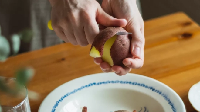 Una persona pelando una papa. / DILIARA GARIFULLINA Una persona pelando una papa. / DILIARA GARIFULLINA