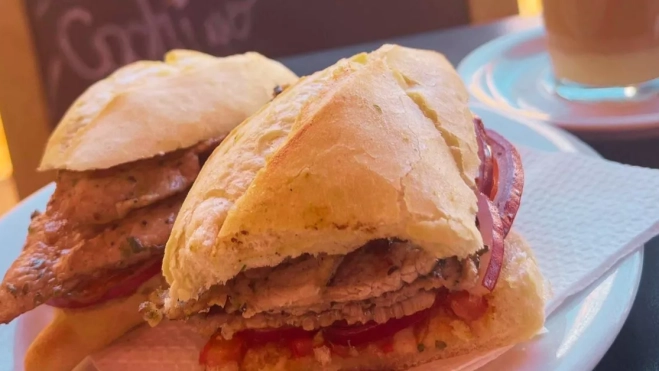 El bocadillo de cochino del bar La Terraza de La Recova viene con cebolla roja, tomate y mojo rojo./ AH.