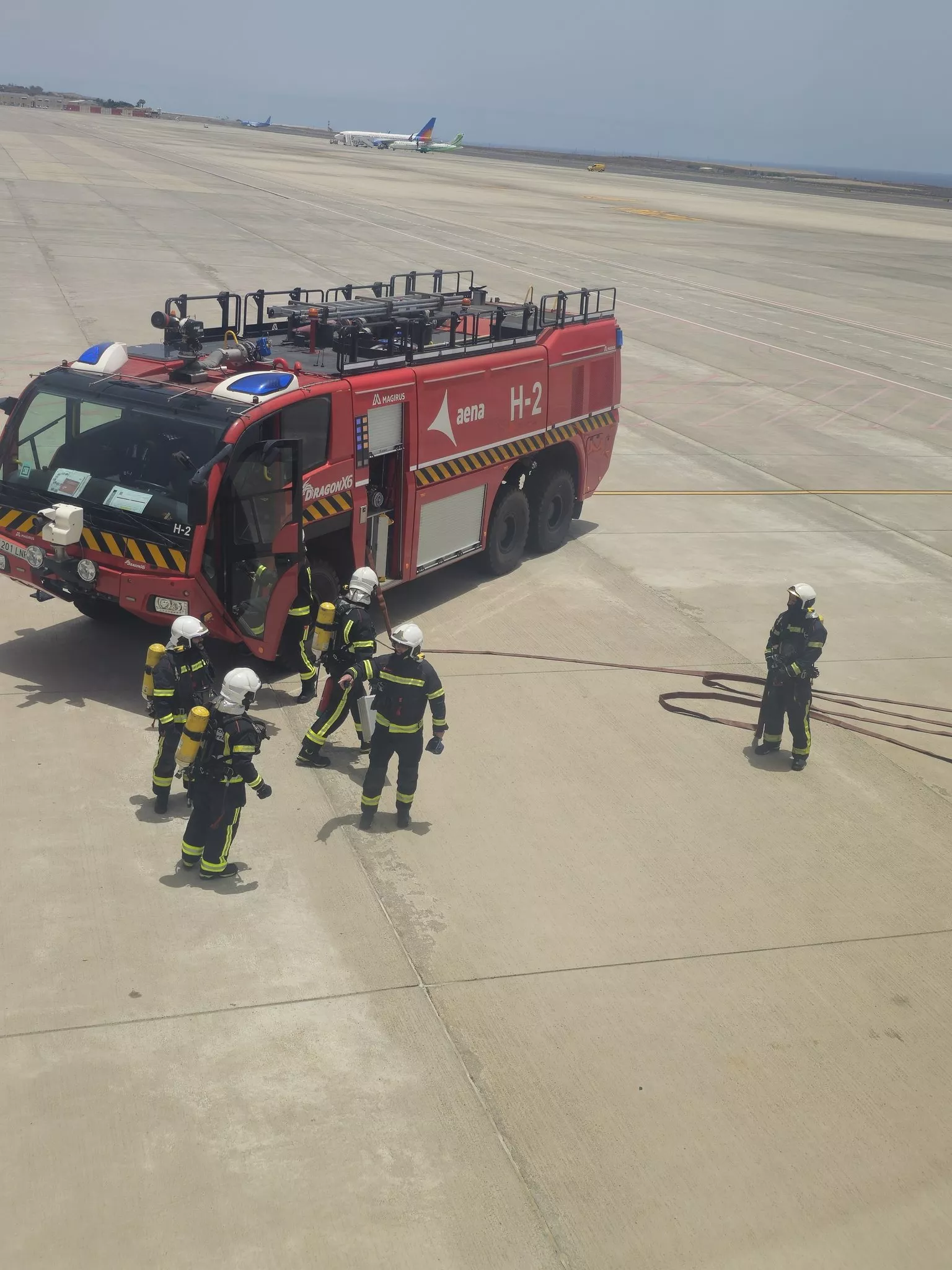 Bomberos en la pista del aeropuerto de Tenerife Sur para entrar en el avión de Air France desviado./ IRENE VIATOR