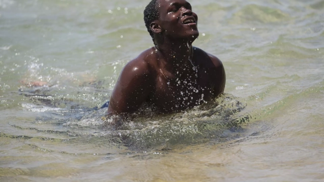 Un migrante aprende a nadar en Las Teresitas (Tenerife). / ALBERTO VALDÉS-EFE