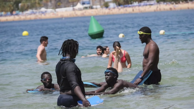 Varios migrantes, durante el curso de natación. / ALBERTO VALDÉS-EFE