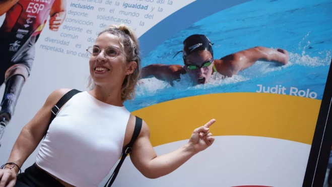 La deportista Judit Rolo, participante en natación en las olimpiadas de Río 2016, posa junto a una fotografía de la exposición itinerante 'Canarias en el Olimpo' /EFE - RAMÓN DE LA ROCHA