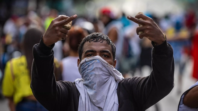 Un hombre, encapuchado, protesta en el centro de Caracas contra Maduro. / HENRY CHIRINOS-EFE