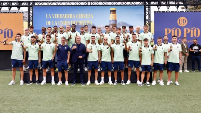 La plantilla de la UD Las Palmas, Luis Carrión y Miguel Ángel Ramírez posan con botellas de la cerveza Pío Pío. / @UDLP_Oficial