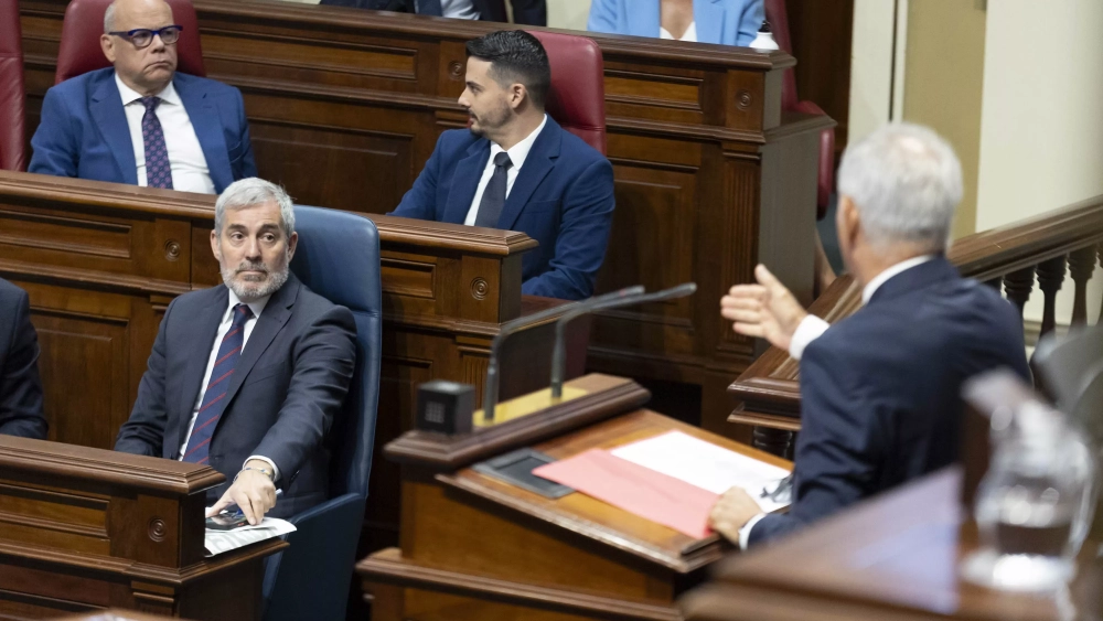 El presidente de Canarias, Fernando Clavijo, escucha la intervención del portavoz del PSOE en el Parlamento autonómico, Sebastián Franquis (d). / MIGUEL BARRETO-EFE