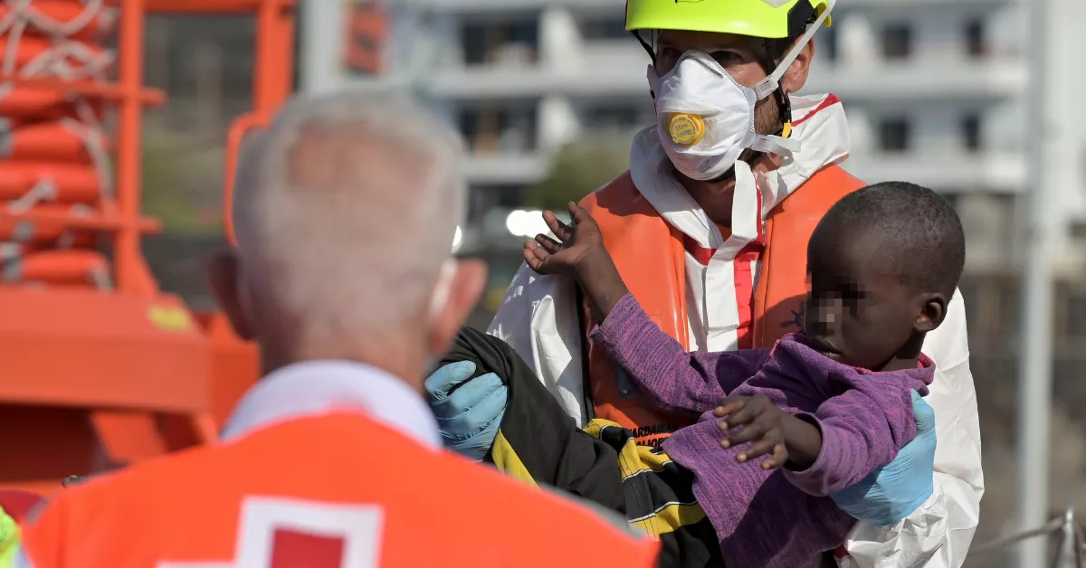 Un miembro de Salvamento Marítimo lleva en brazos un bebé tras llegar a puerto de La Restinga, El Hierro, este miércoles, el buque con 57 migrantes rescatados de un cayuco. EFEGelmert Finol