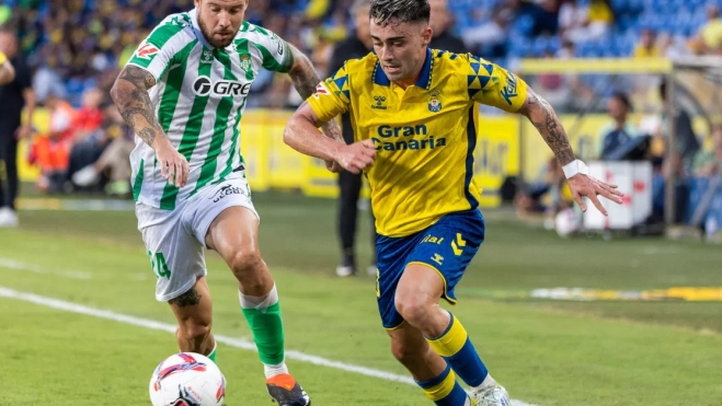 El centrocampista de la UD Las Palmas Alberto Moleiro (d) lucha con Aitor Ruibal, del Betis / EFE - QUIQUE CURBELO