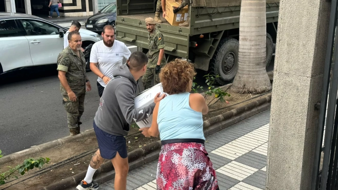 Voluntarios cargan el material en uno de los camiones. / AH