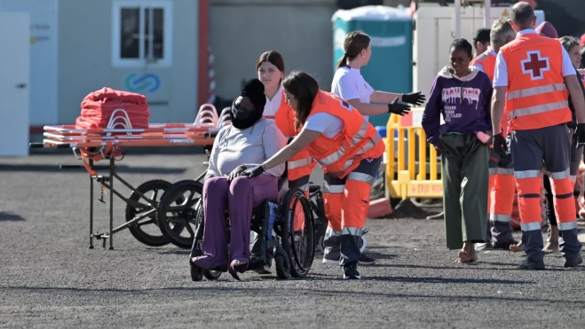 Dos trabajadoras de Cruz Roja ayudan a uno de los migrantes rescatados en la tarde de este martes tras llegar en cayuco / EFE - GELMERT FINOL Dos trabajadoras de Cruz Roja ayudan a uno de los migrantes rescatados en la tarde de este martes tras llegar en cayuco / EFE - GELMERT FINOL