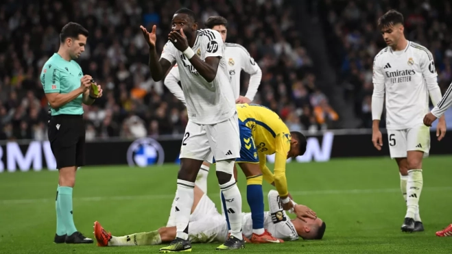 El defensa alemán del Real Madrid Antonio Rüdiger reacciona tras una falta a Lucas Vázquez (en el suelo) este domingo / EFE - FERNANDO VILLAR