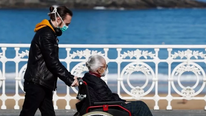 Un joven atiende a una persona dependiente / EFE Un joven atiende a una persona dependiente / EFE